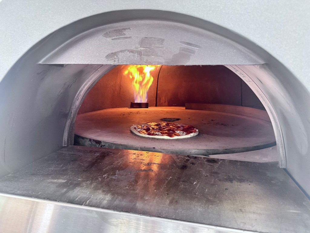 a pizza inside a wood burning oven