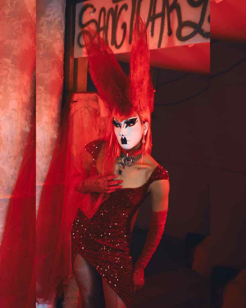 A drag queen in a red dress and wig