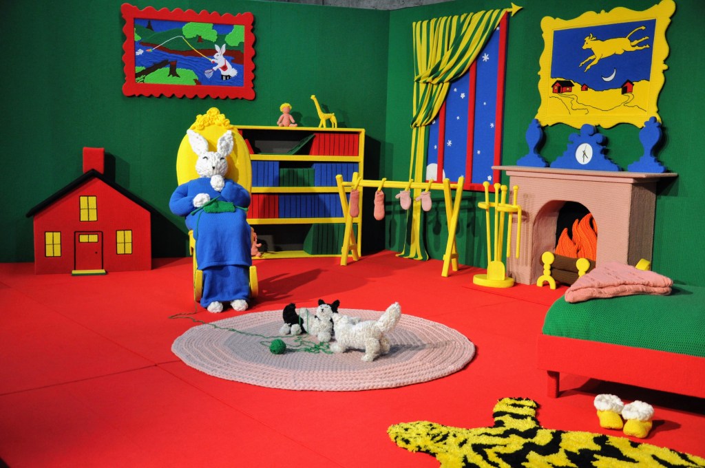 two cats play with yarn on a rug