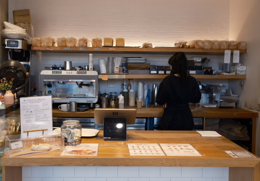 person behind counter of a coffee shop