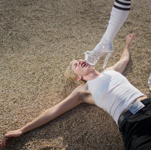 Denver musician Kitty Crimes lies on the ground as a high-heeled boot comes down to her face.