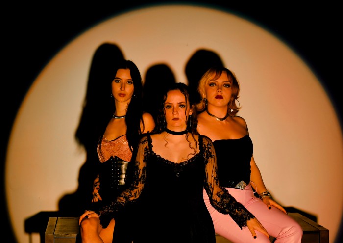 three women posing in a spotlight