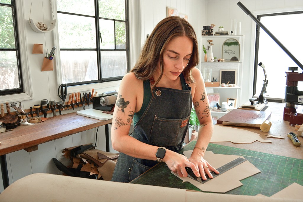 A woman works in a leather studio