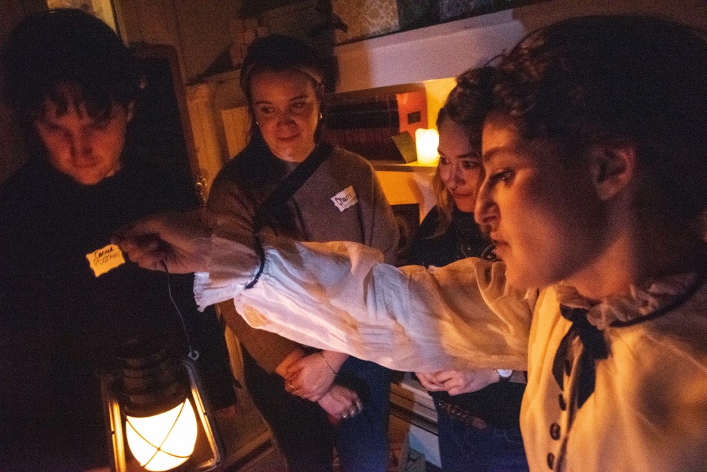 A person holds a lantern around others.