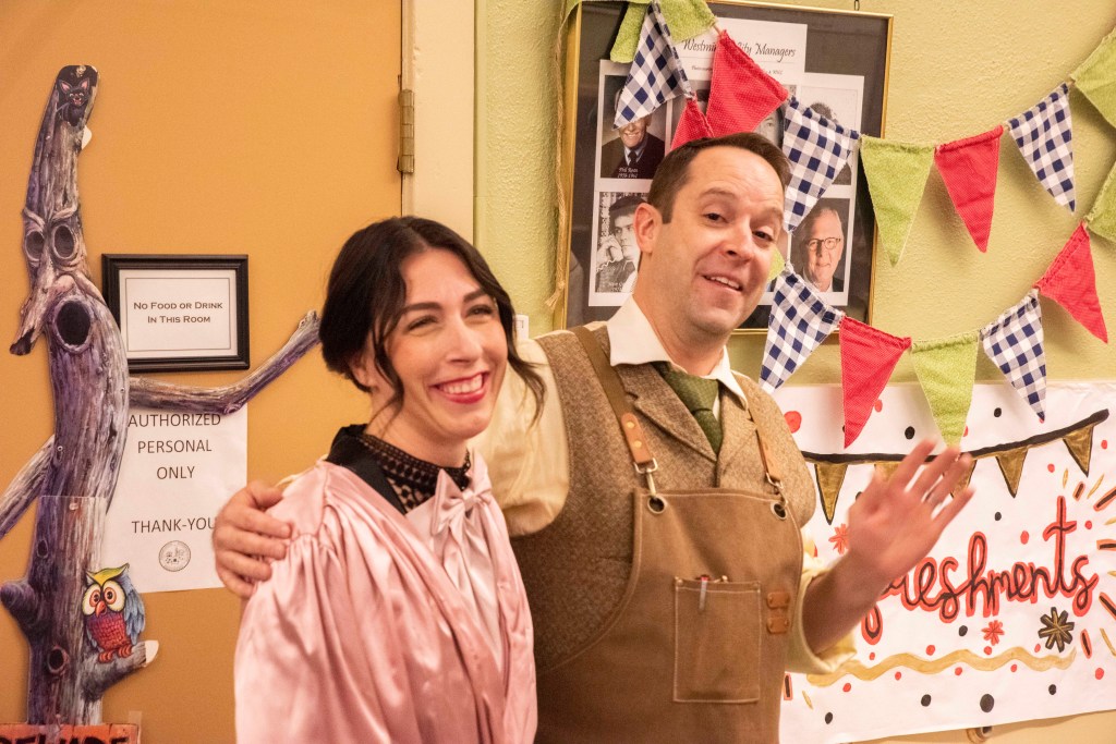 Two people stand together in a colorful environment.