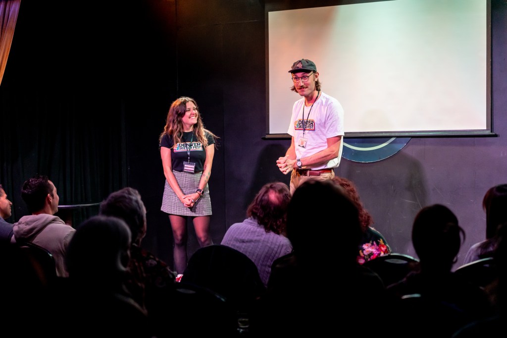 Two people stand onstage.