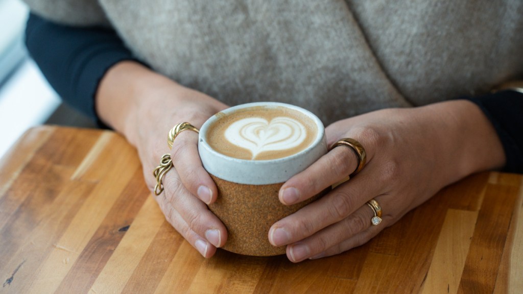 hands holding latte