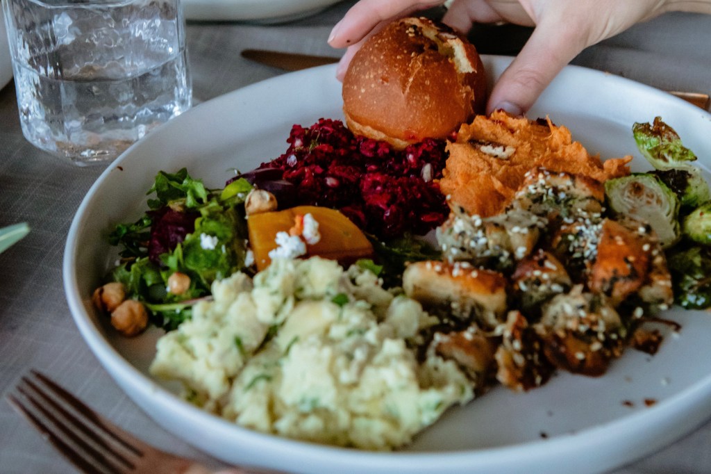 Stuffing, mashed potatoes and other Thanksgiving dishes from Edible Beats on a white plate