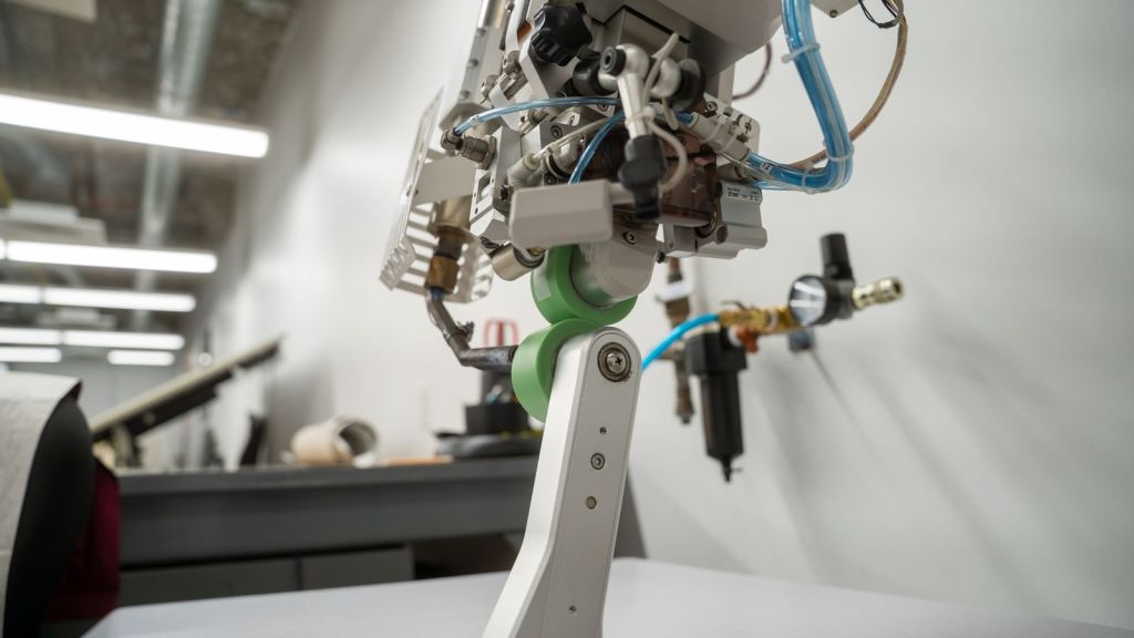 Two green rollers pressed against each other on the seam sealer machine