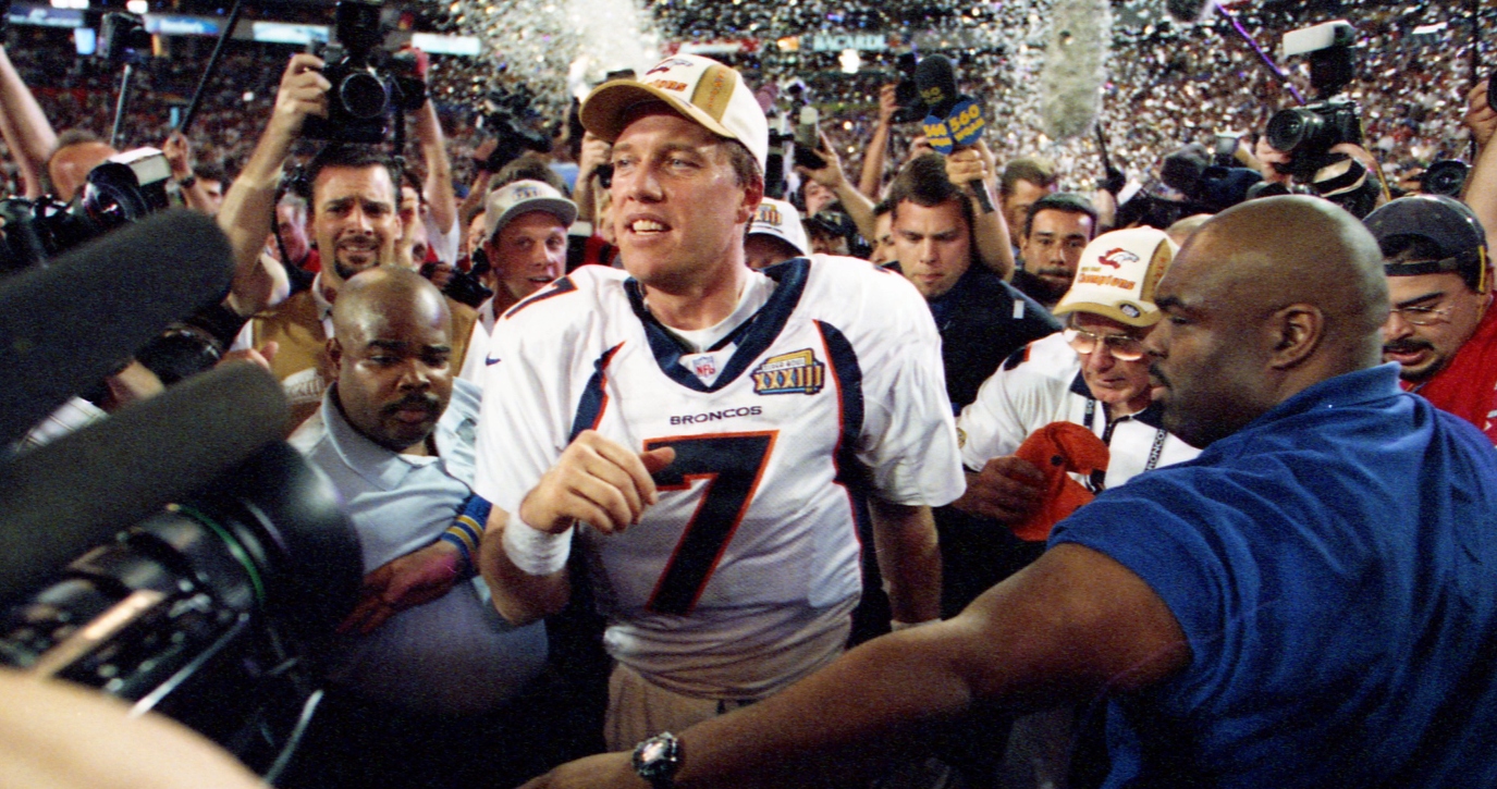 A football player surrounded by media and fans