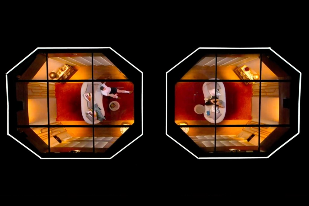 A man and woman seen from above in separate rooms, talking to one another through a wall.