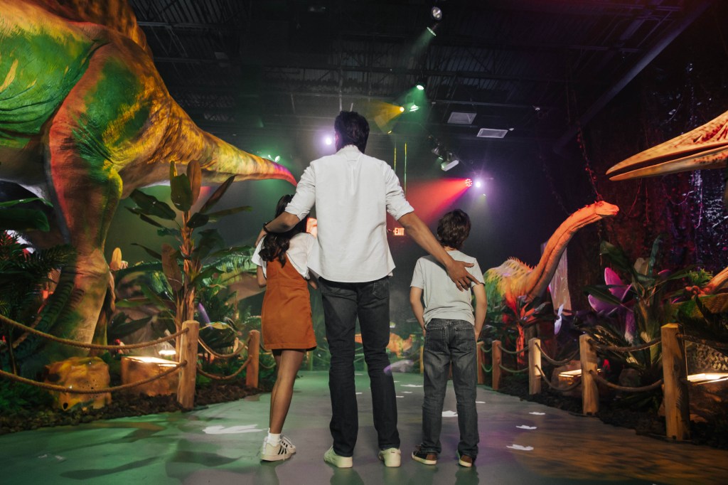 People gather around dinosaur animatronics.