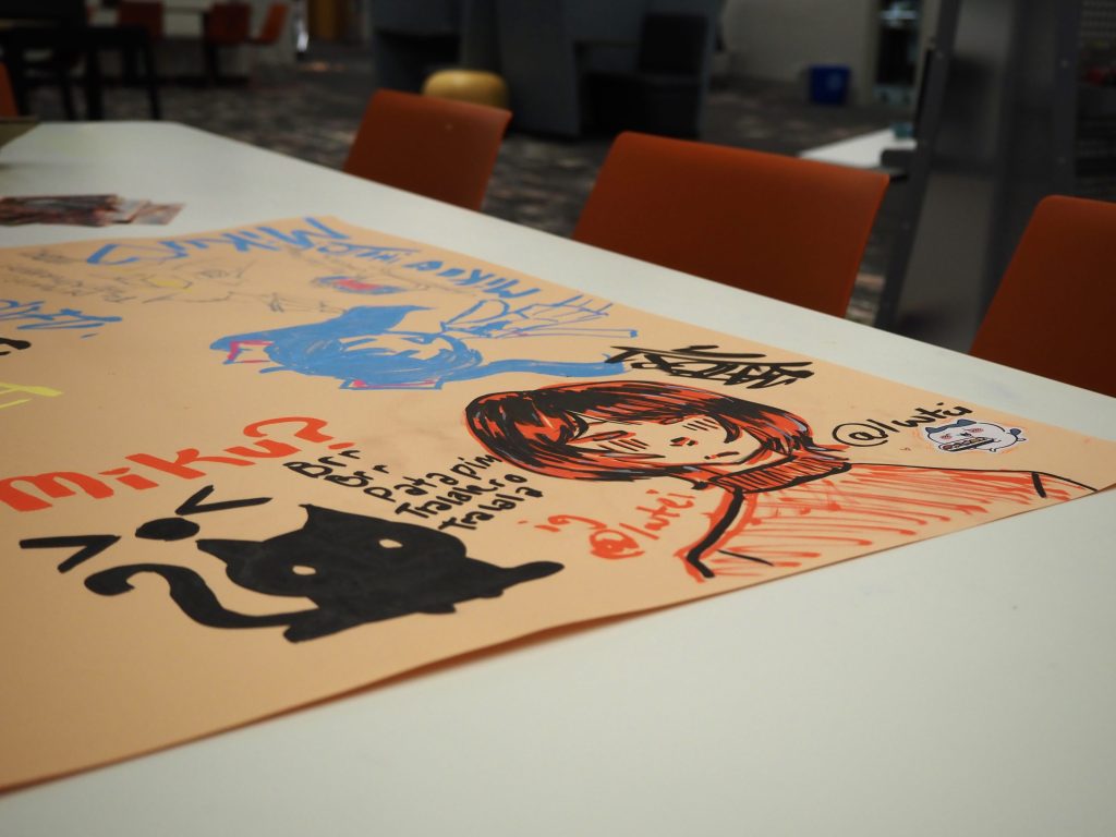 A paper with a drawing of people and a cat