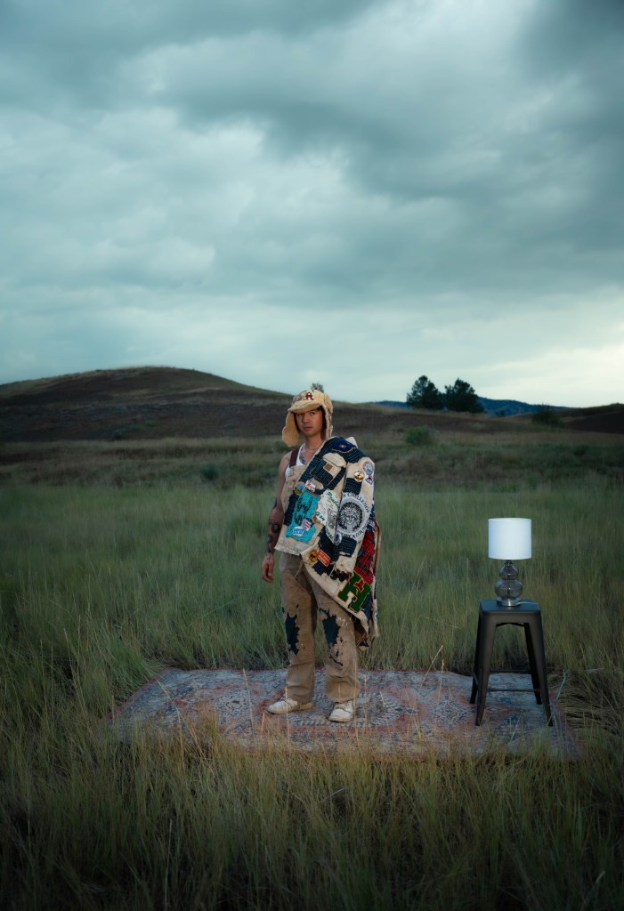 Joshua Ryuju models a jacket, pants, and hat made of reclaimed vintage materials.