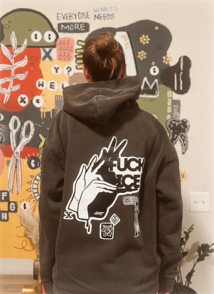 A person wearing a sweatshirt that says "Fuck ICE."