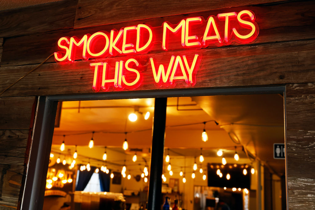 "smoked meats this way" sign