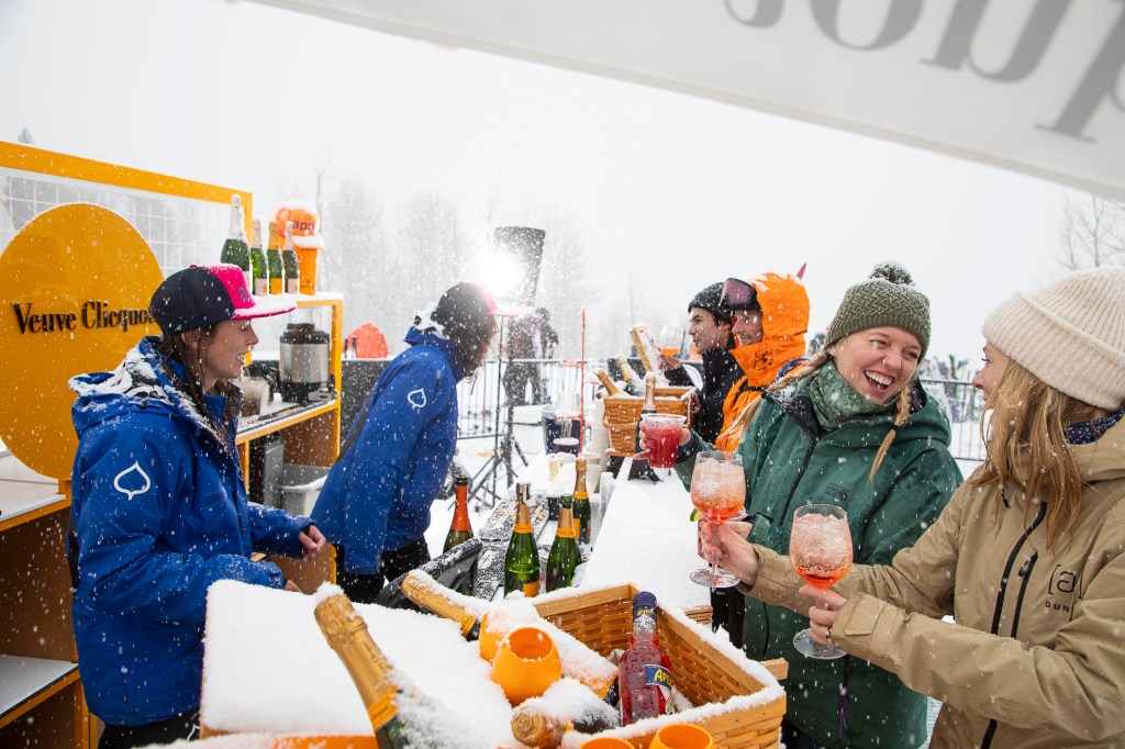 People around The Cabin's outdoor bar, ordering champagne and Aperol spritzes