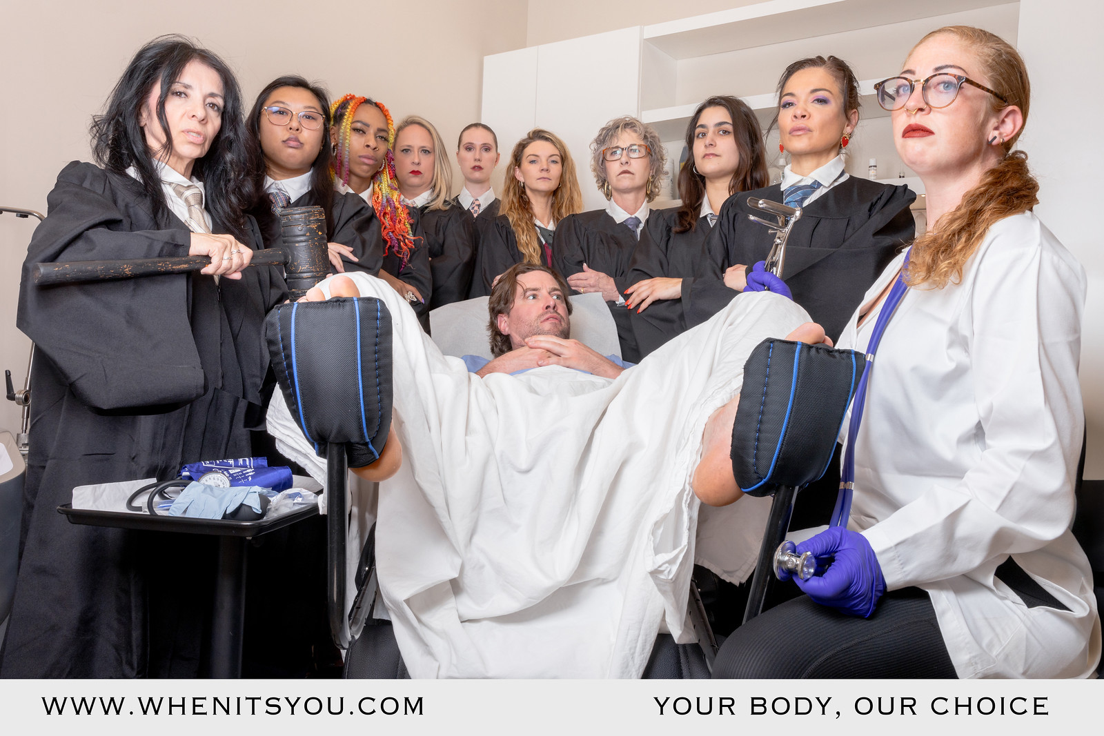 a man on a medical table surrounded by women in judge robes