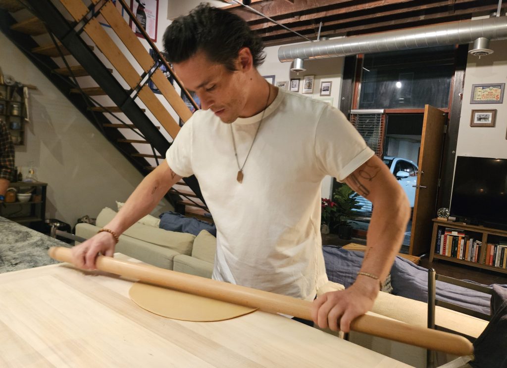 a man rolling pasta by hand