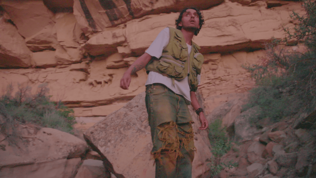 man standing with background of reddish rocks