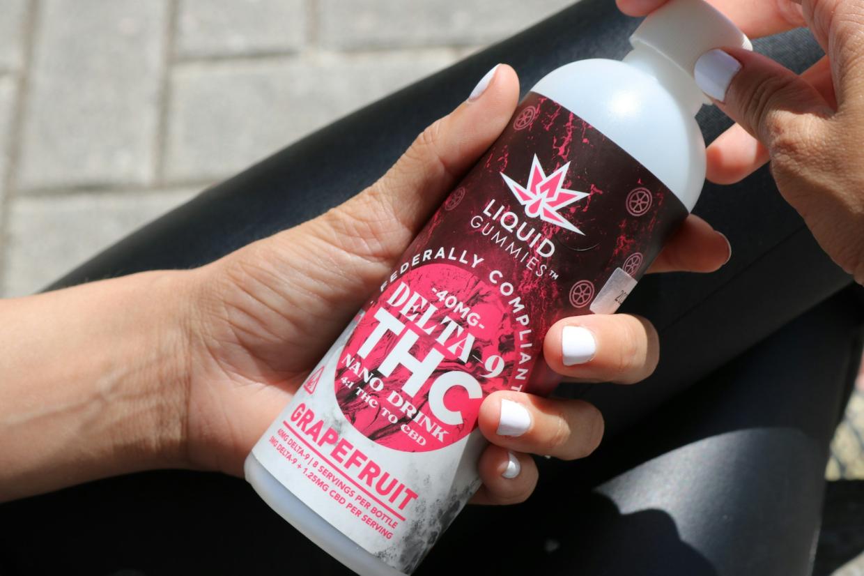 woman holds hemp THC beverage