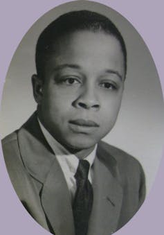 An oval black-and-white photo of a Black man wearing a suit and tie.