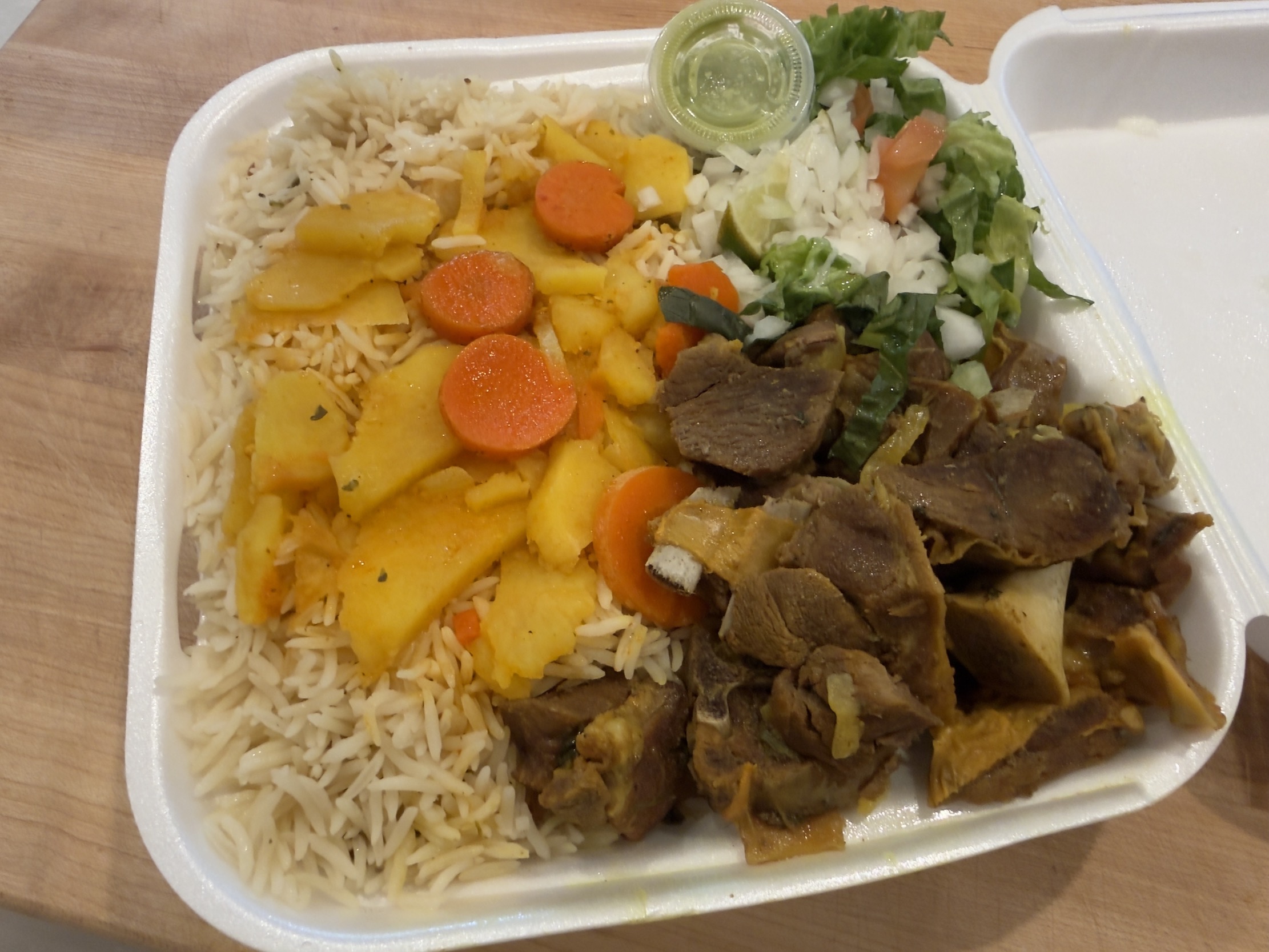 a plate of goat meat and rice