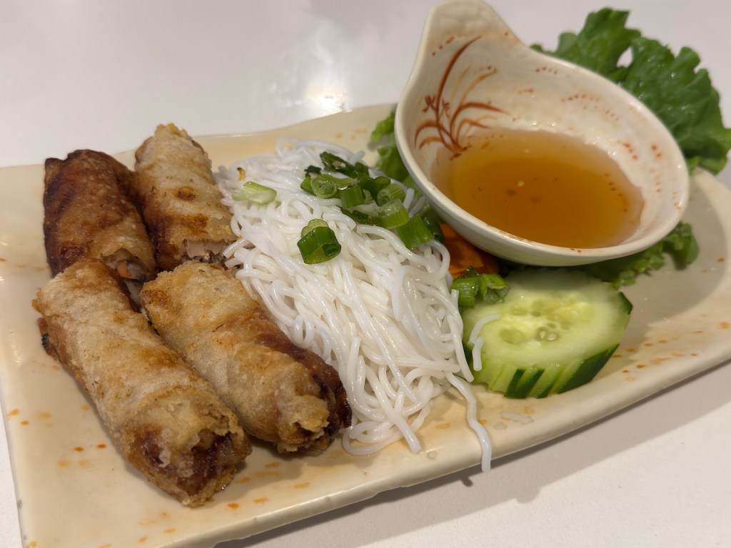 a plate of eggrolls and noodles