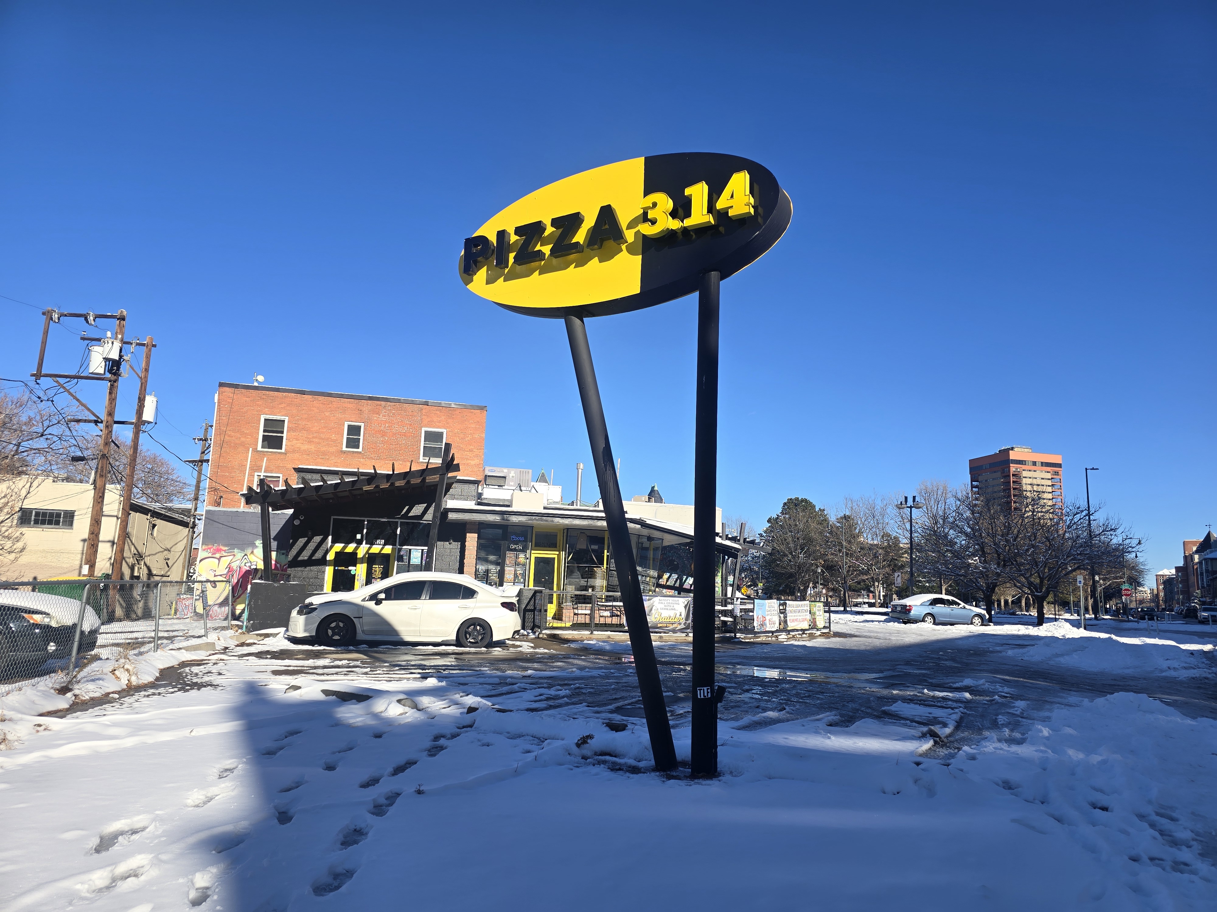 "pizza 3.14" sign in front of a building