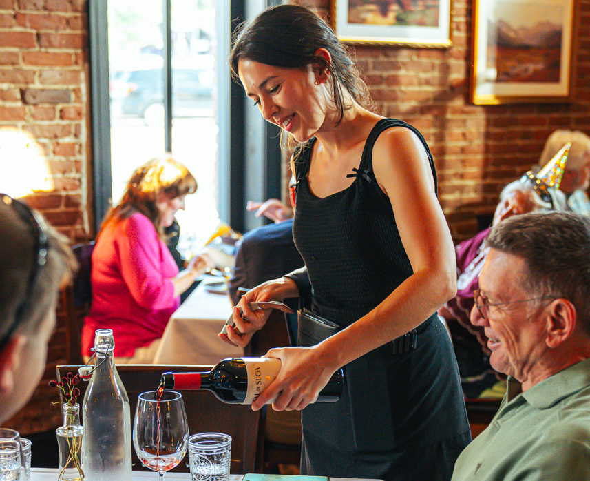 a server pouring wine