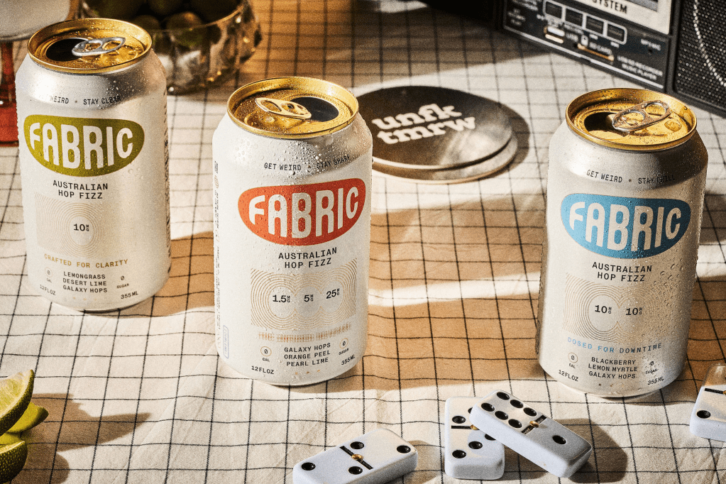 Aluminum cans of Fabric on a white tablecloth next to dominoes