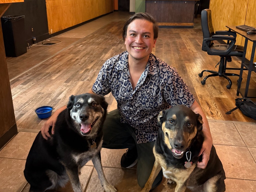 man posing with two dogs