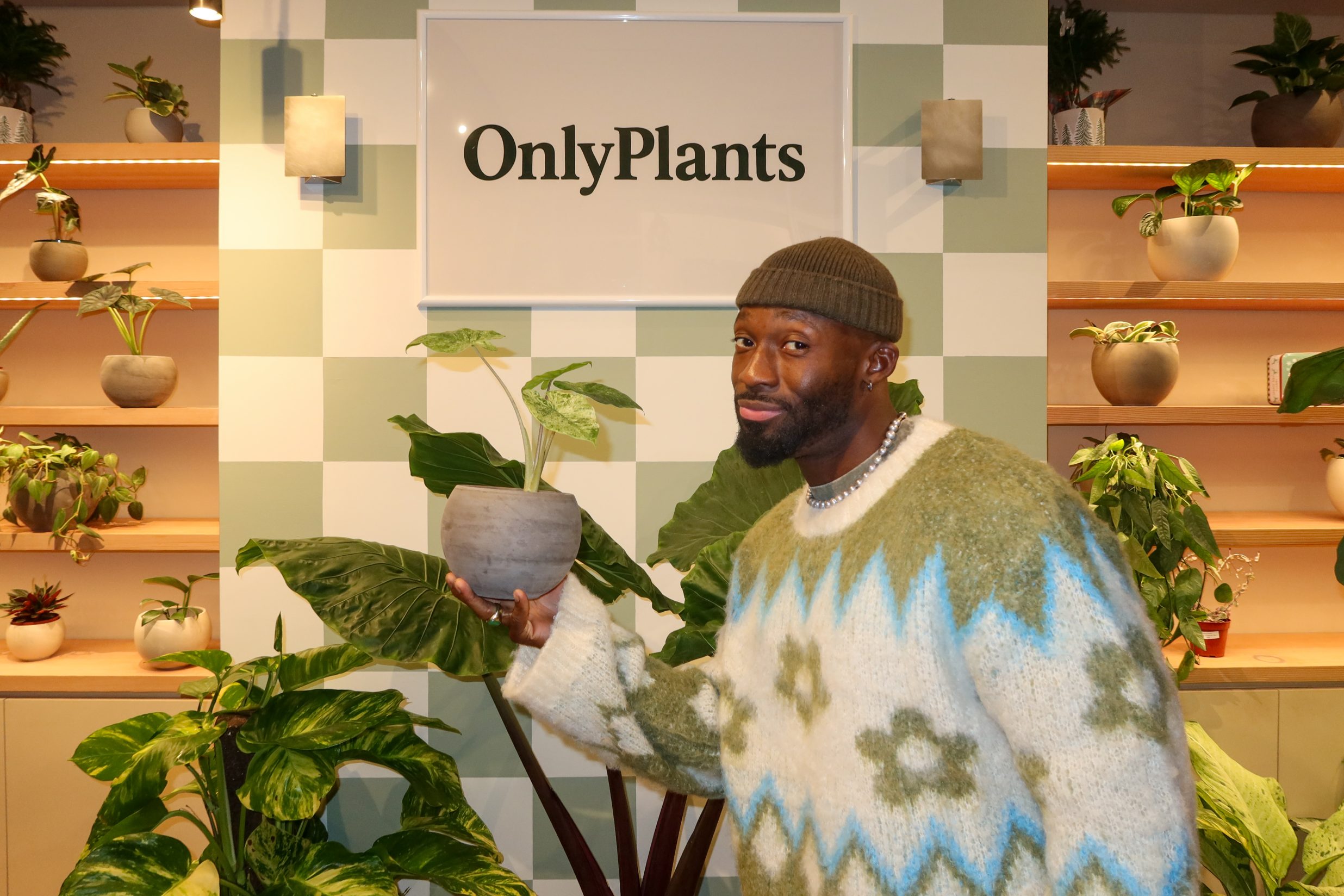 A man holds a plant in a plant store