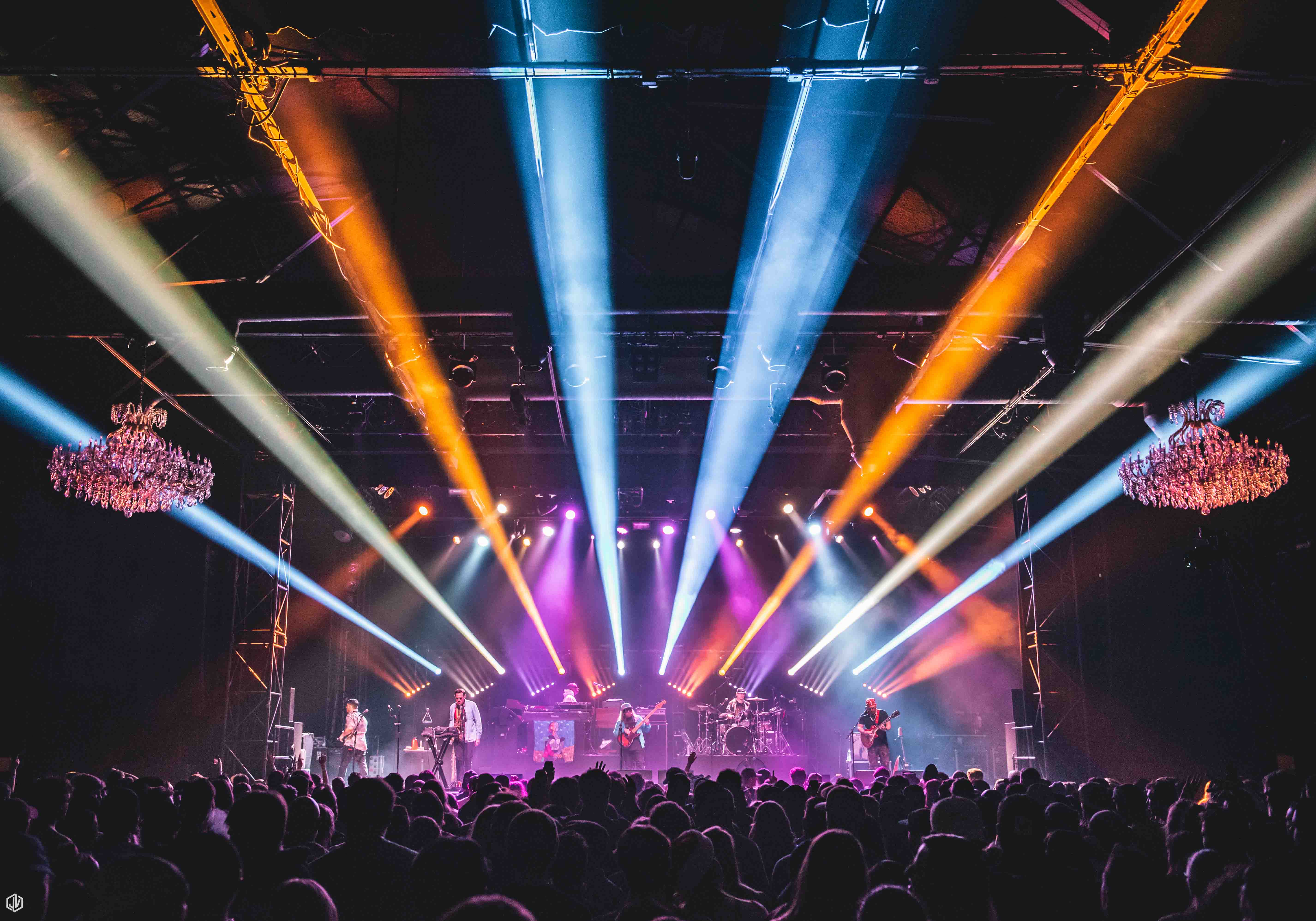 a band performing on stage with colorful lights