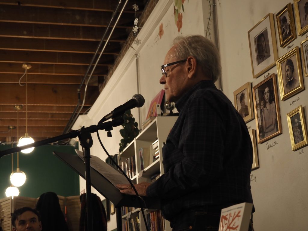 A man reads at a microphone