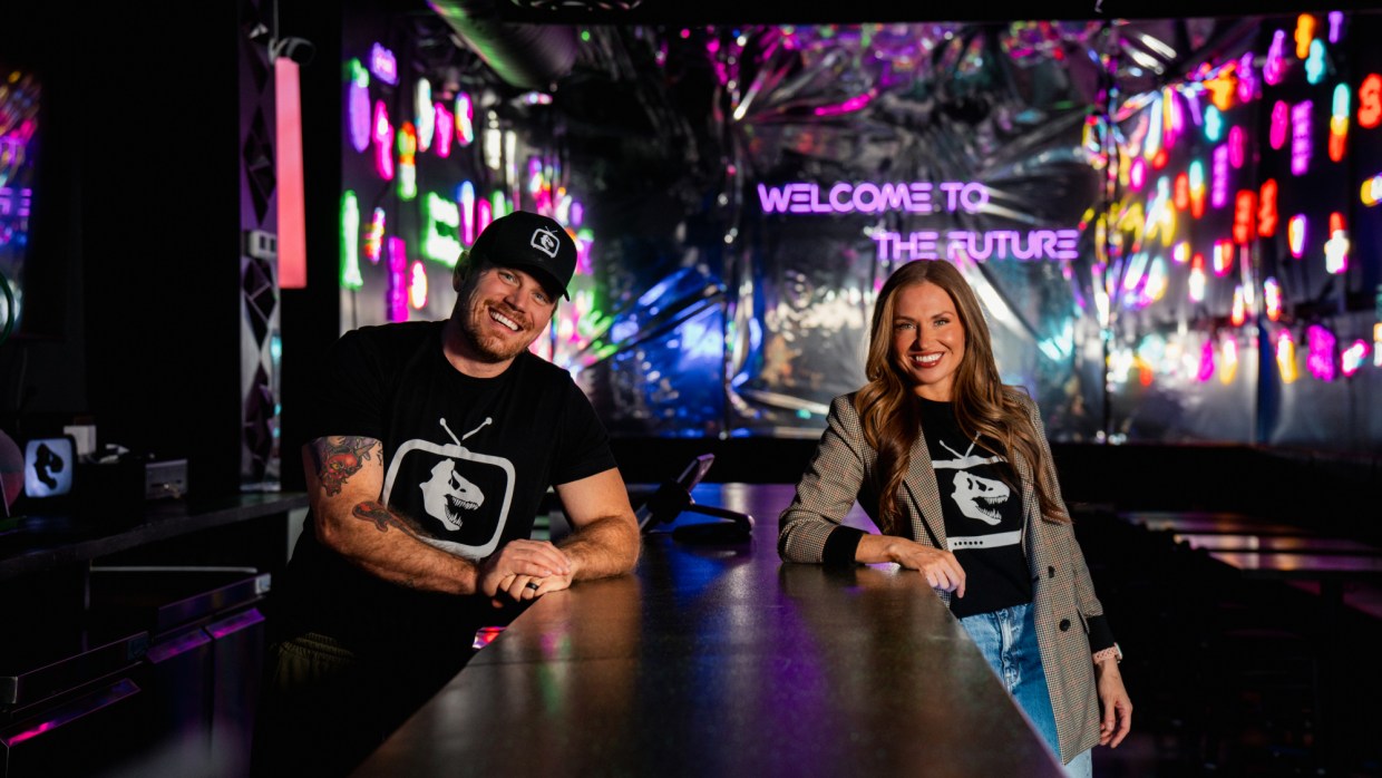 two people posing on either side of a bar