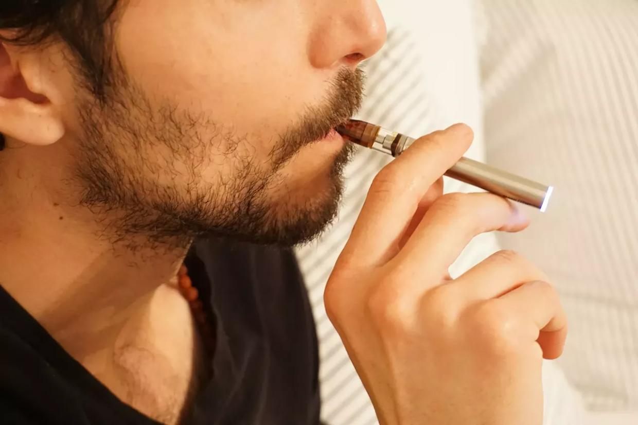 man hits THC vape