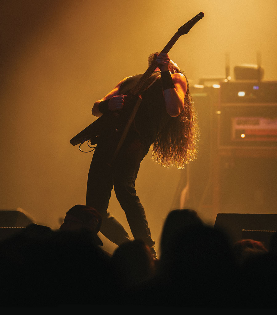 man bowing back while playing guitar