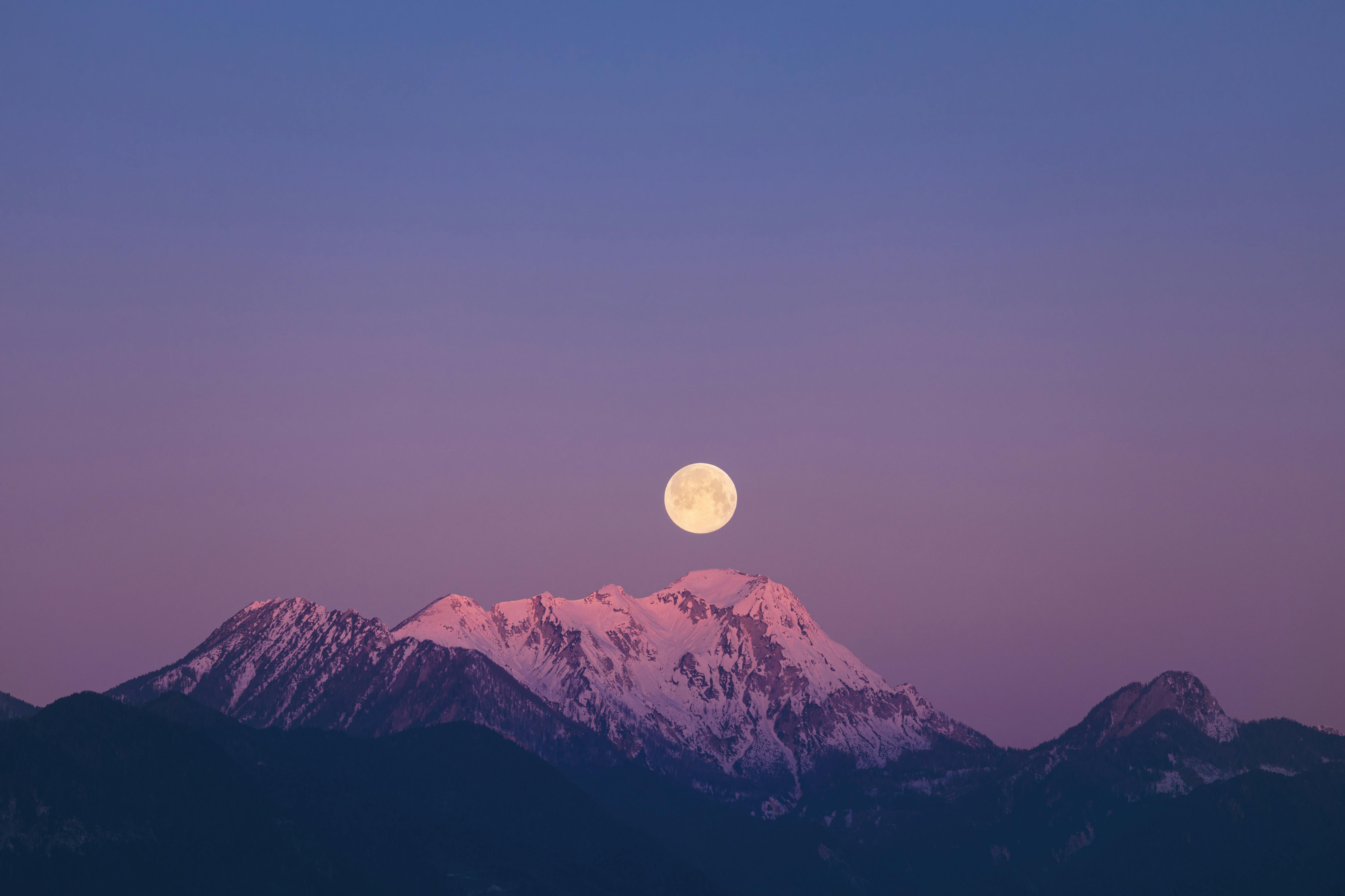 A moon rising over mountains