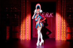 Nini Coco entering the RuPaul's Drag race workroom in a rainbow latex outfit.