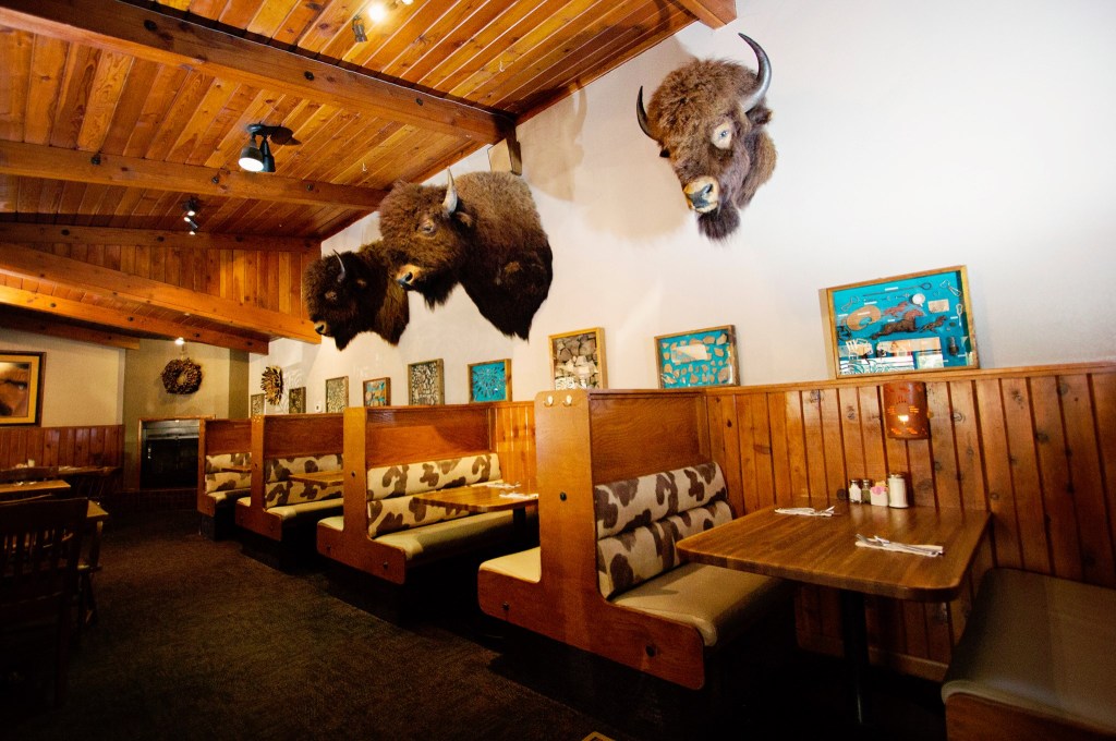 buffalo heads hanging over booths in a restaurant