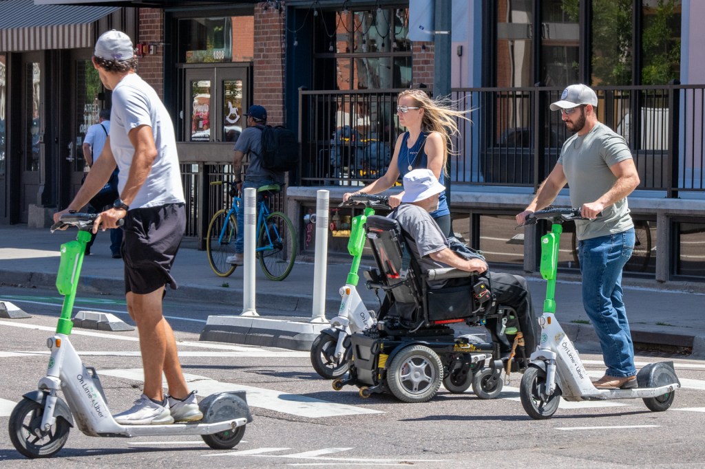 people ride e-scooters in denver