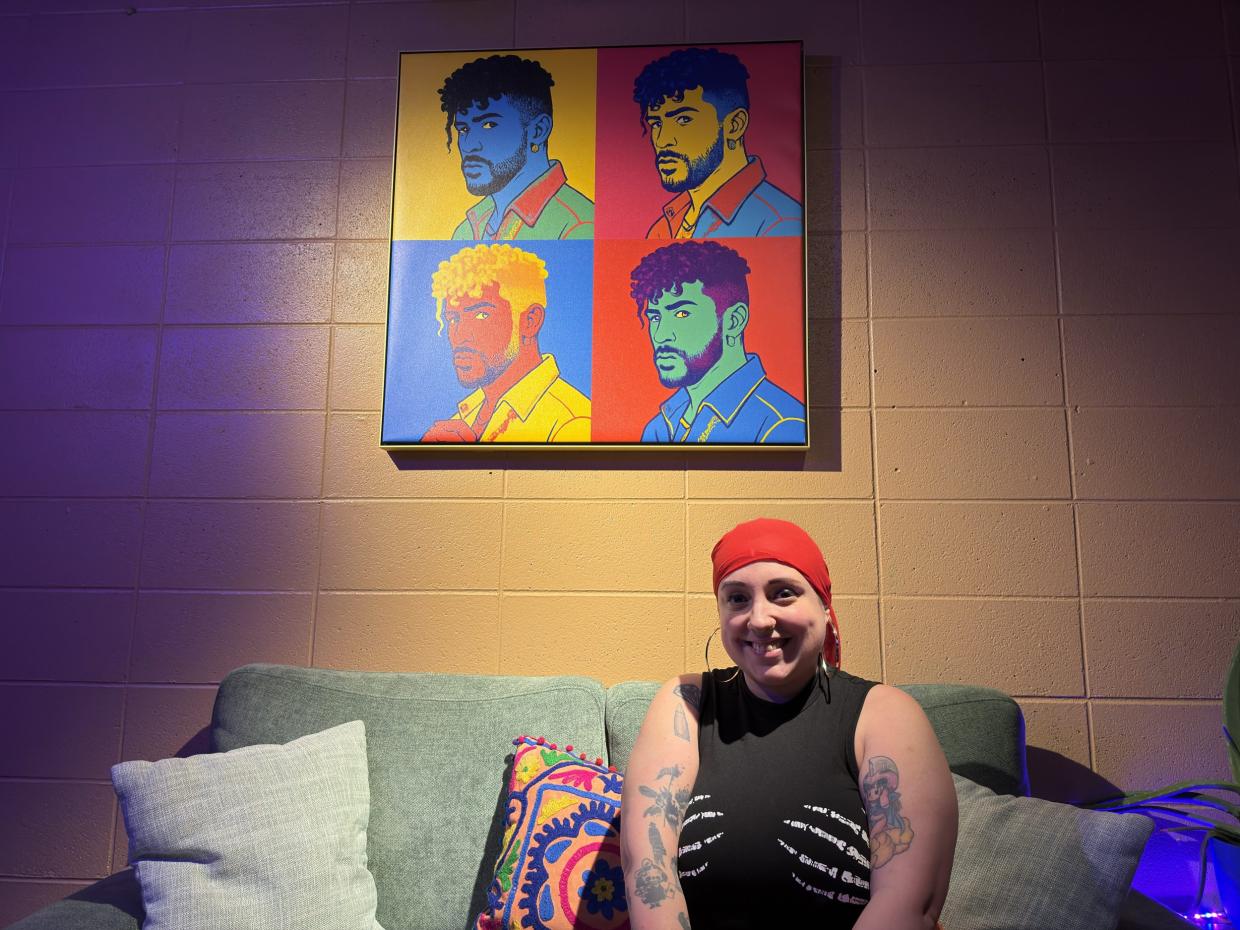 a woman posing beneath a portrait.