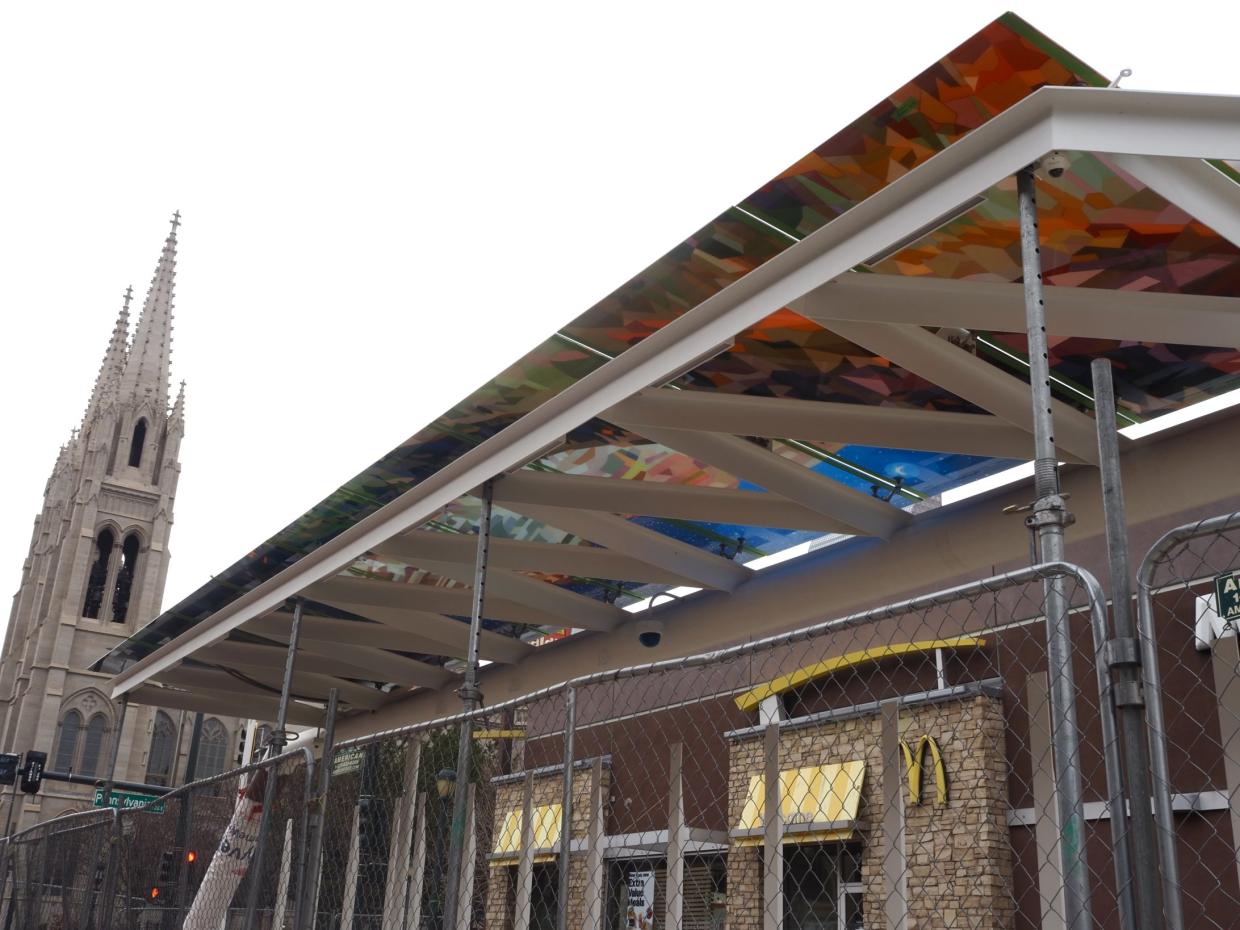 A bus station with art under its arch.