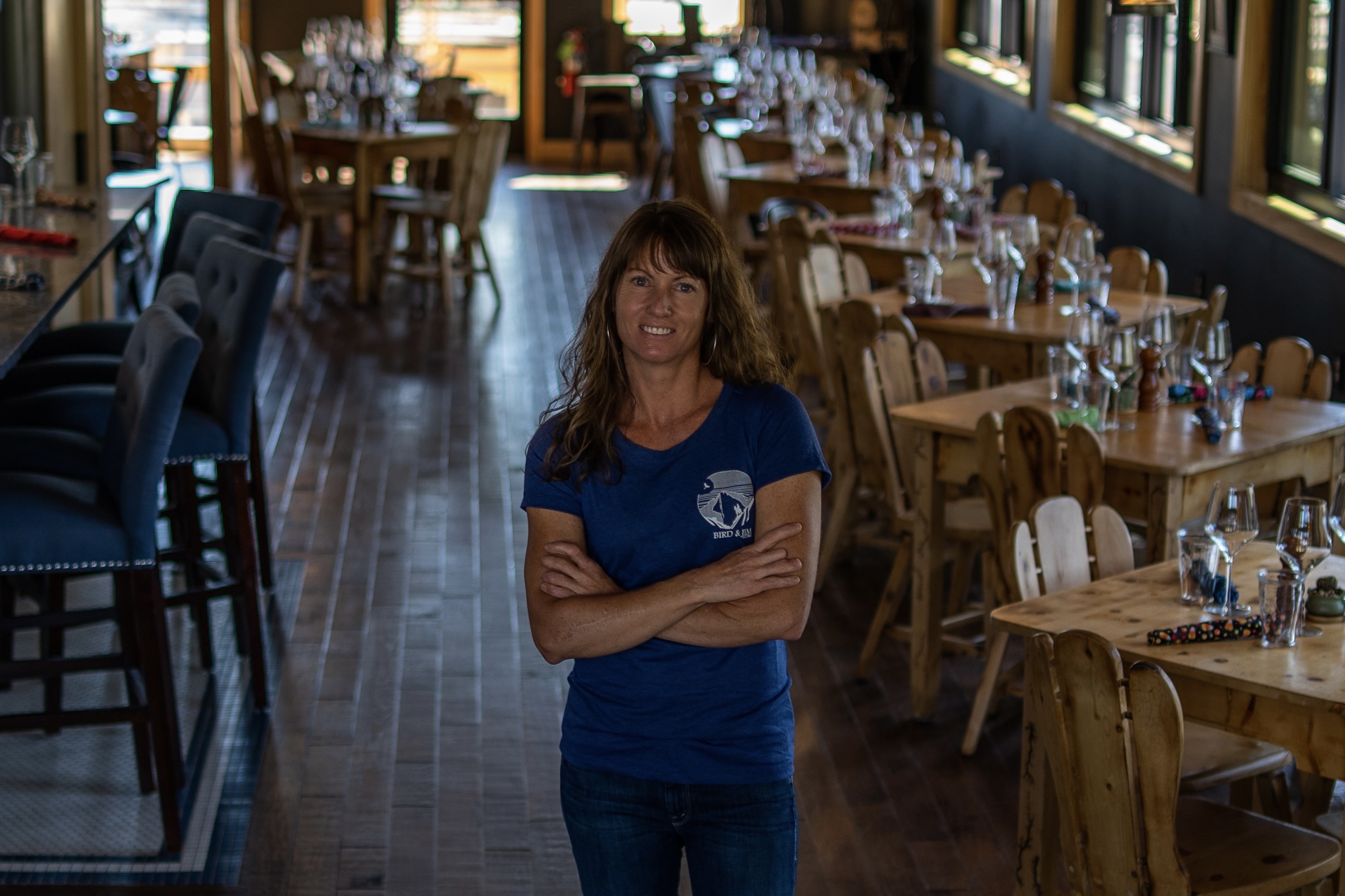 Melissa Strong in a blue Bird & Jim T-shirt, posed inside the restaurant dining room