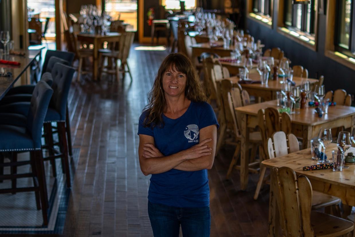Melissa Strong in a blue Bird & Jim T-shirt, posed inside the restaurant dining room