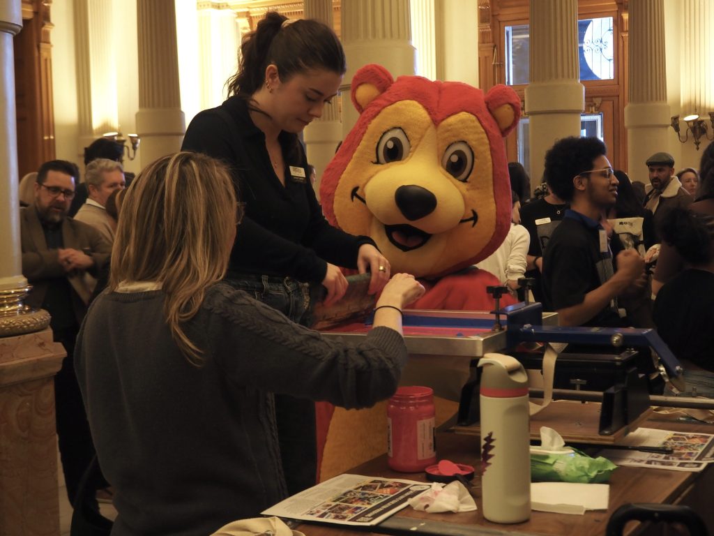 People stand at a printmaking station