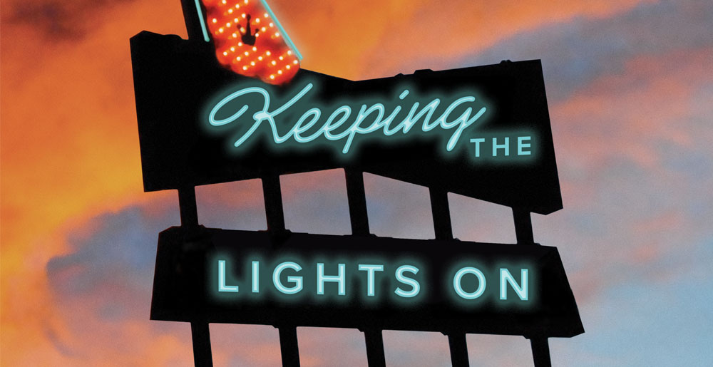 A neon sign reading "Keeping the Lights On"