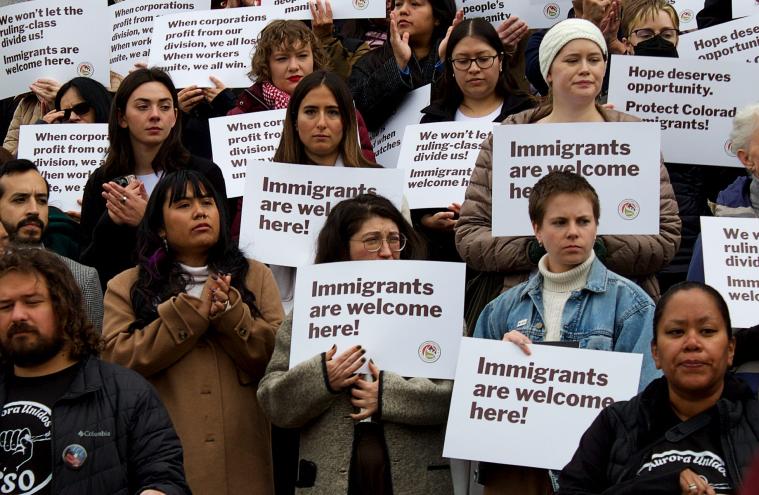 immigrant activists hold signs at colorado capitol