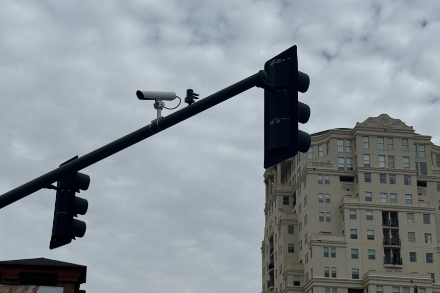 A surveillance camera sits atop traffic lights at a Denver intersection.